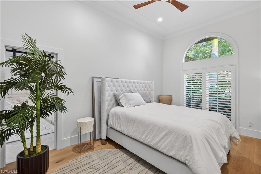 7657 Ponte Verde Way Naples, FL 34109 - Photo 25 of 41 a bedroom with a large bed and a potted plant