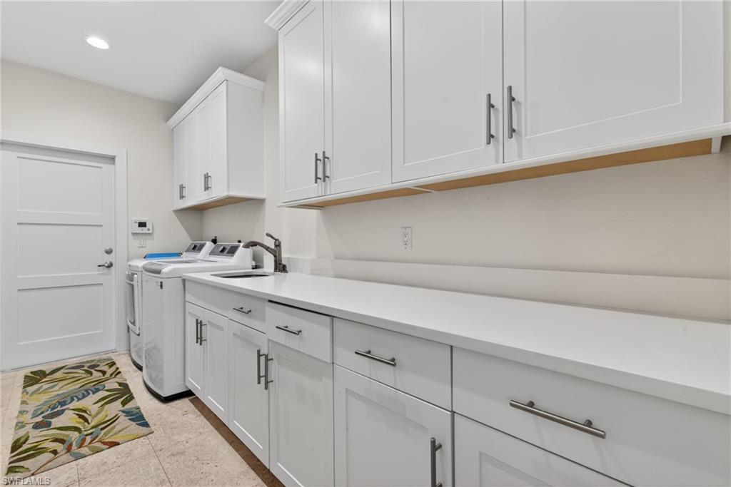7657 Ponte Verde Way Naples, FL 34109 - Photo 30 of 41 a kitchen with granite countertop white cabinets and white appliances
