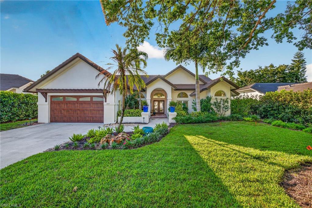 7657 Ponte Verde Way Naples, FL 34109 - Photo 5 of 41 a front view of a house with a garden and plants