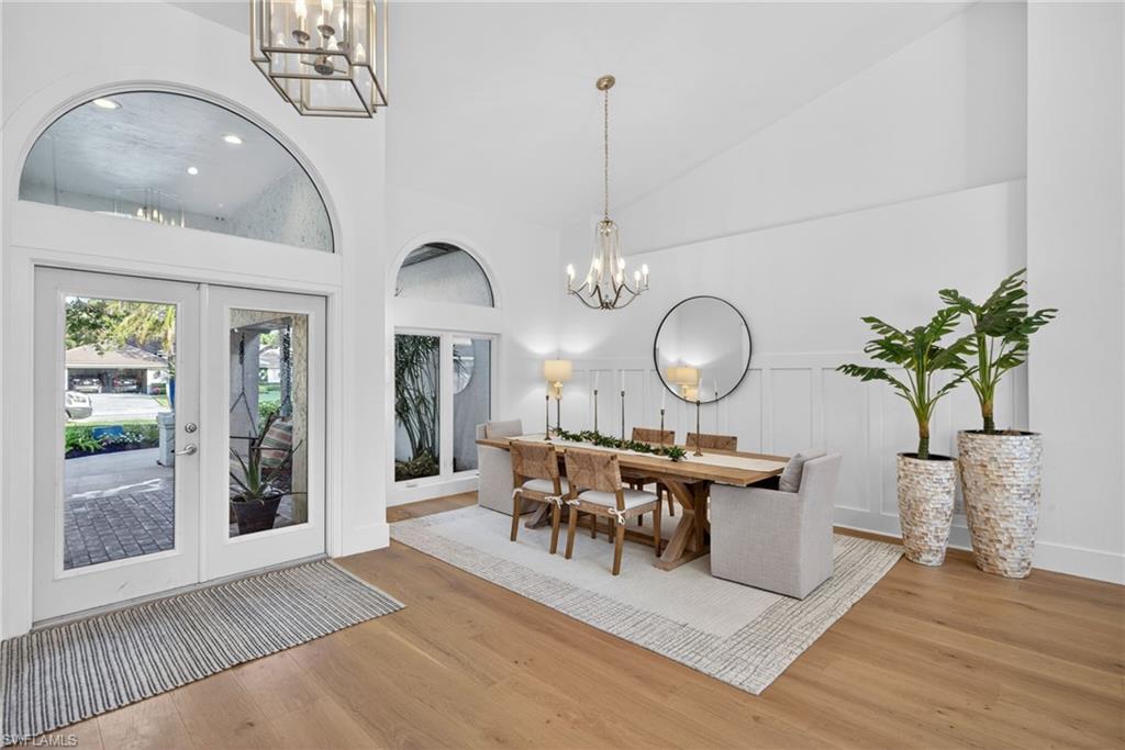 7657 Ponte Verde Way Naples, FL 34109 - Photo 7 of 41 a view of a dining room with furniture a chandelier and wooden floor