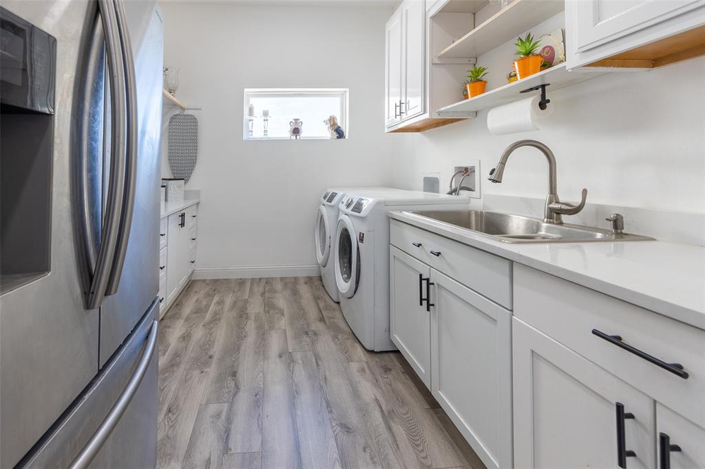 2630 Rockhill Road Aubrey, TX 76227 - Photo 23 of 36 a kitchen with sink a refrigerator and washer