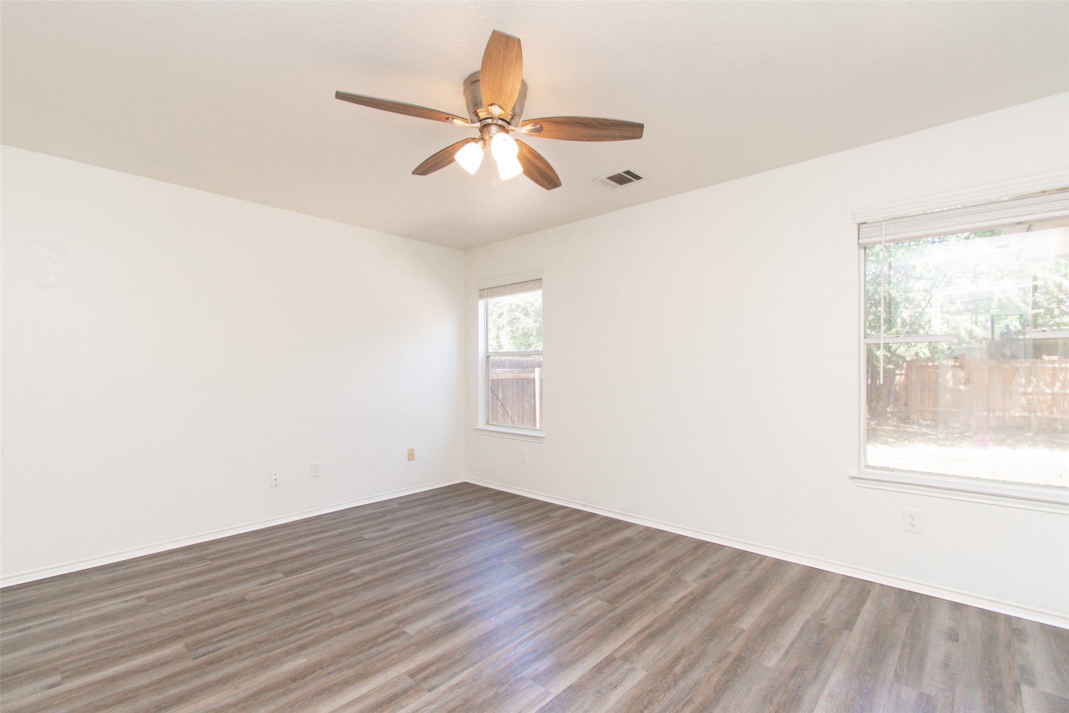 1436 Roxanne's Run Pflugerville, TX 78660 - Photo 7 of 24 Smooth wood-look flooring and multiple windows anchor this versatile, neutral-toned room.