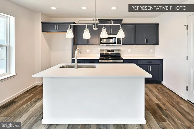 a kitchen with a sink a microwave and cabinets