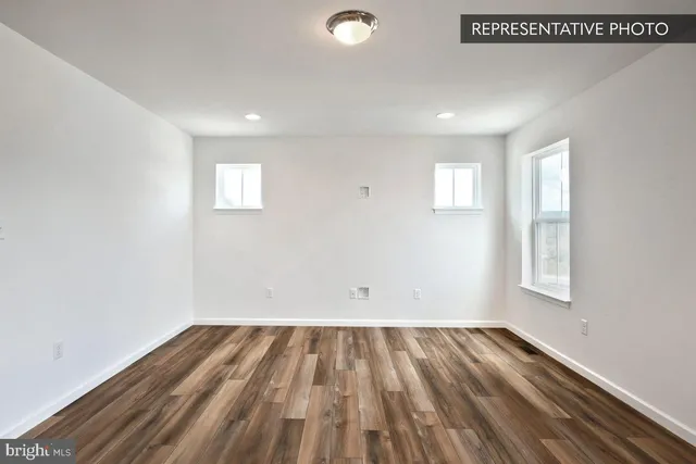 a view of a room with kitchen appliances and wooden floor