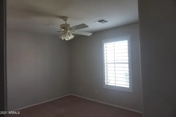 an empty room with a window and a fan