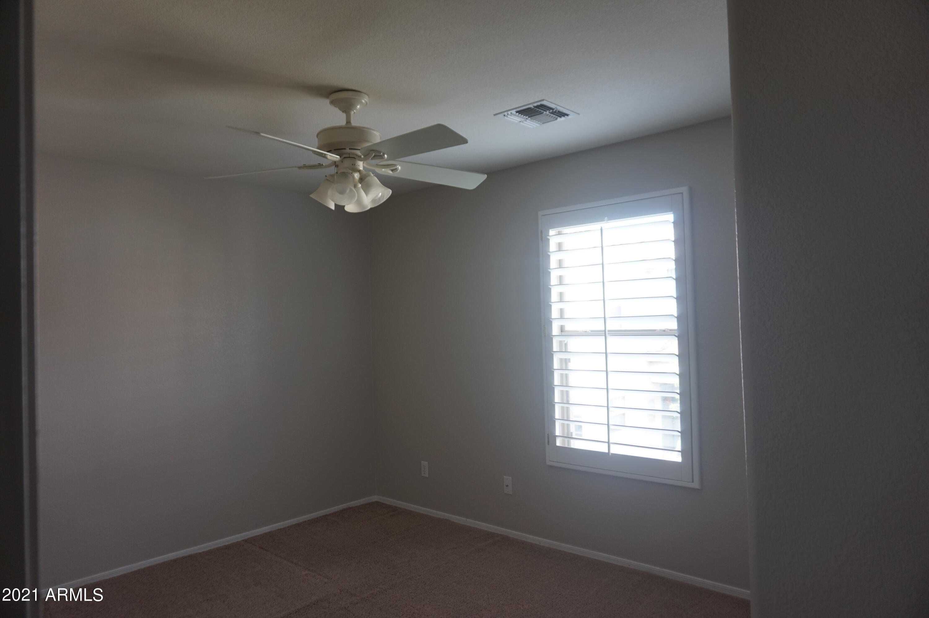 2719 South Sailors Way Gilbert, AZ 85295 - Photo 12 of 14 an empty room with a window and a fan
