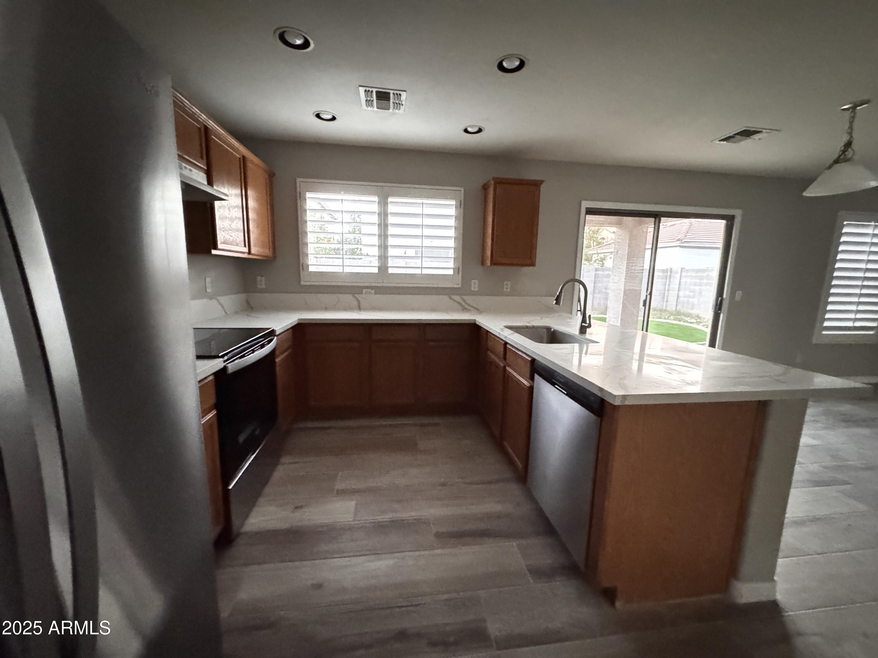 2719 South Sailors Way Gilbert, AZ 85295 - Photo 4 of 14 a large kitchen with stainless steel appliances granite countertop a sink dishwasher a stove and a refrigerator