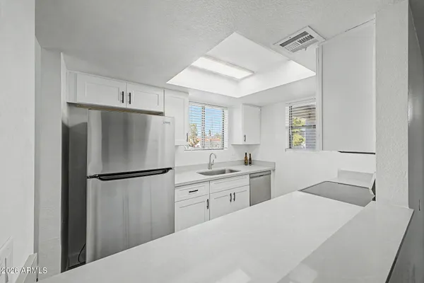 a kitchen with cabinets and steel stainless steel appliances