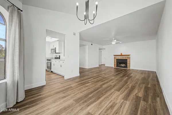 a view of empty room with wooden floor and fireplace