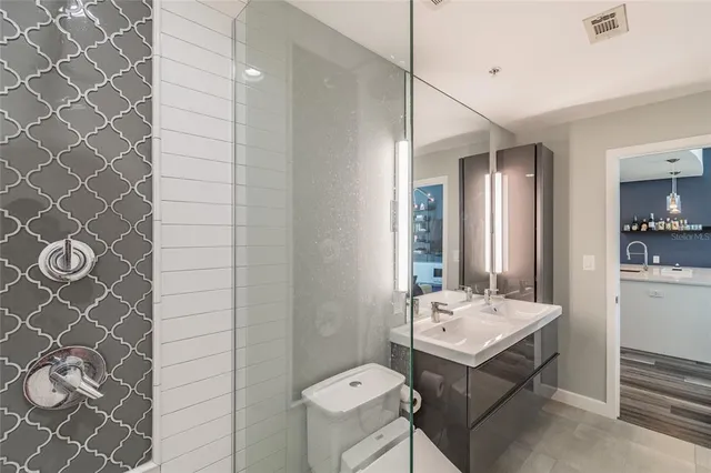 a bathroom with a sink mirror and a toilet