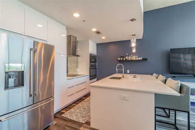 a kitchen with stainless steel appliances a refrigerator sink and microwave