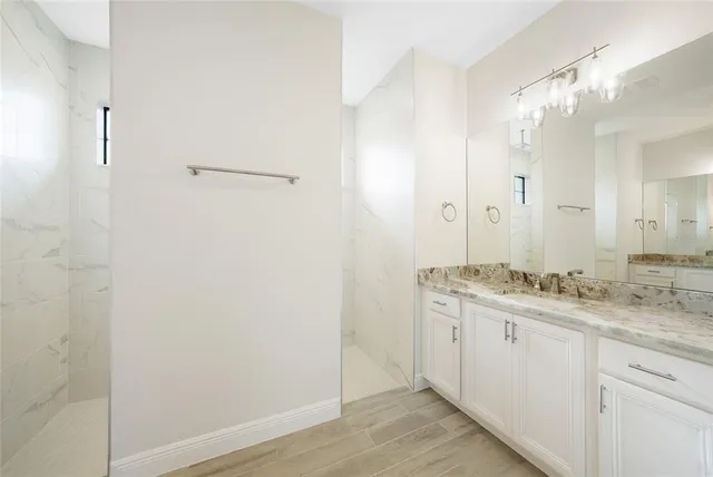 a bathroom with a granite countertop sink a toilet and a large mirror