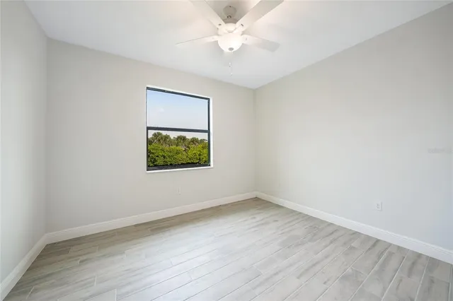 a bathroom with a granite countertop sink a toilet a mirror and shower