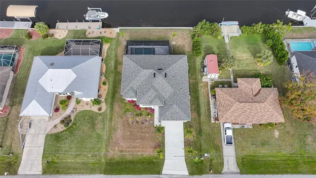 an aerial view of a house with a garden and lake view