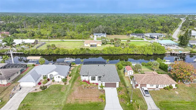 an aerial view of a house with swimming pool patio and lake view