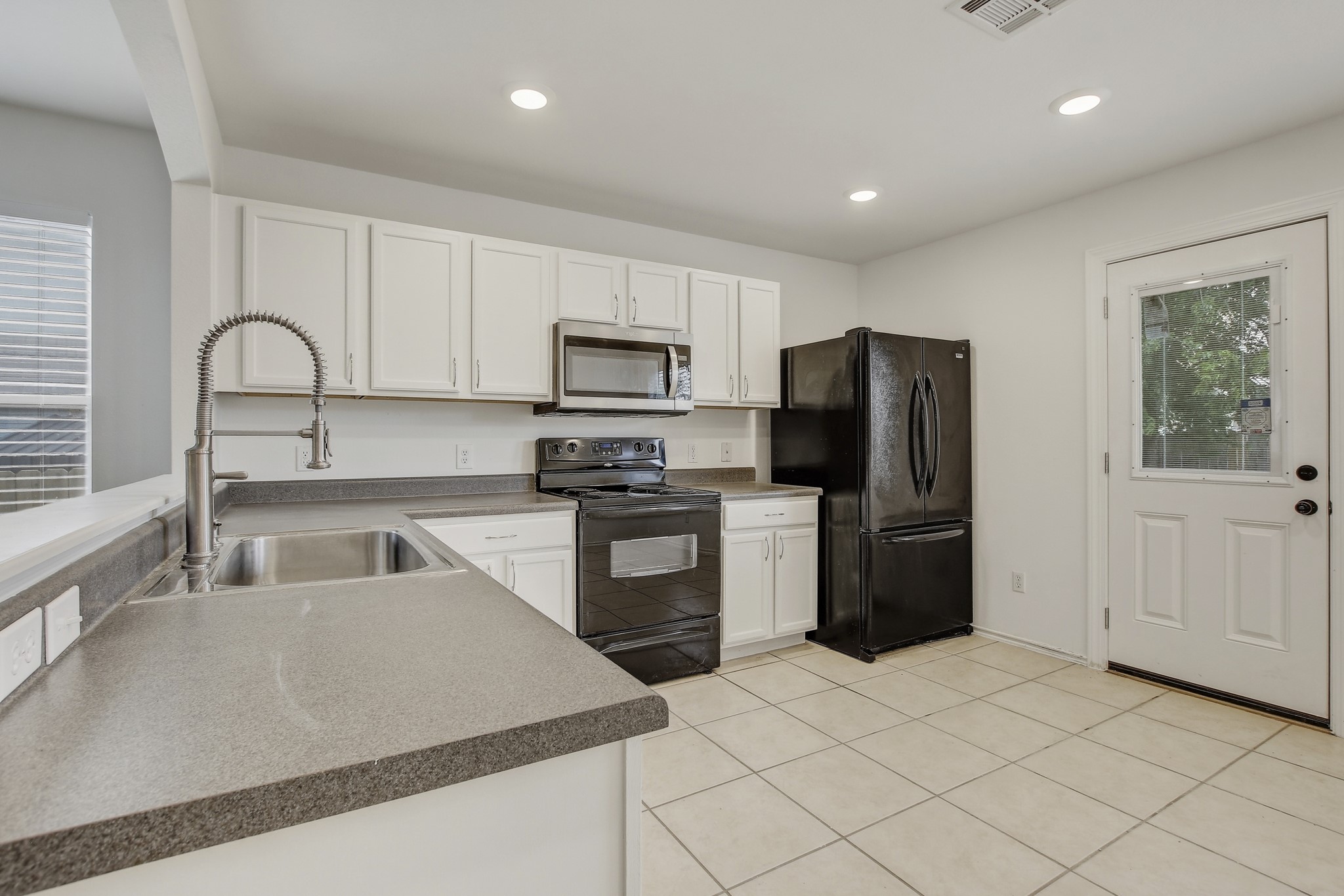 315 Northern Trail Leander, TX 78641 - Photo 13 of 30 a kitchen with granite countertop a refrigerator and a sink
