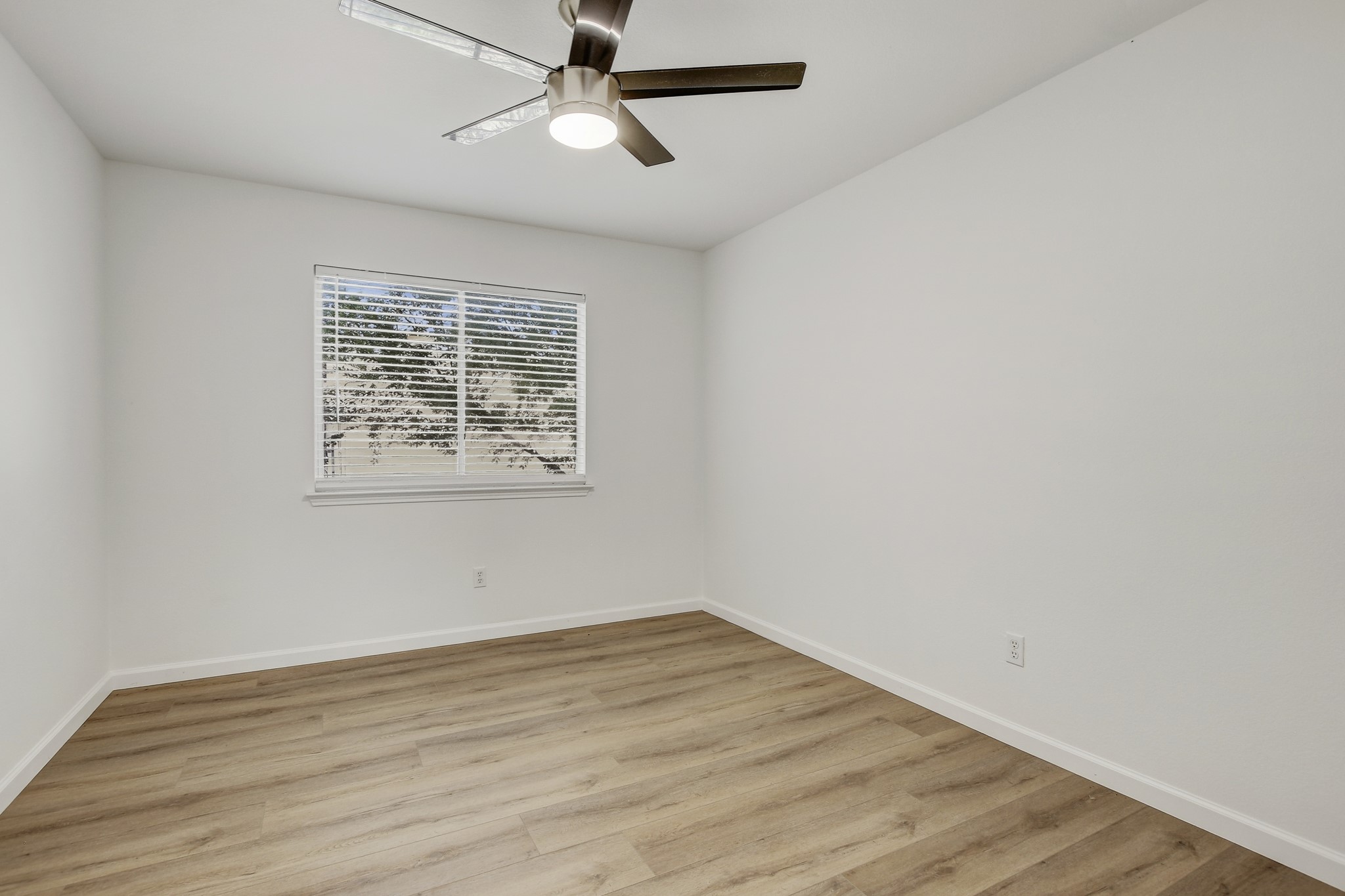 315 Northern Trail Leander, TX 78641 - Photo 21 of 30 an empty room with wooden floor ceiling fan and windows