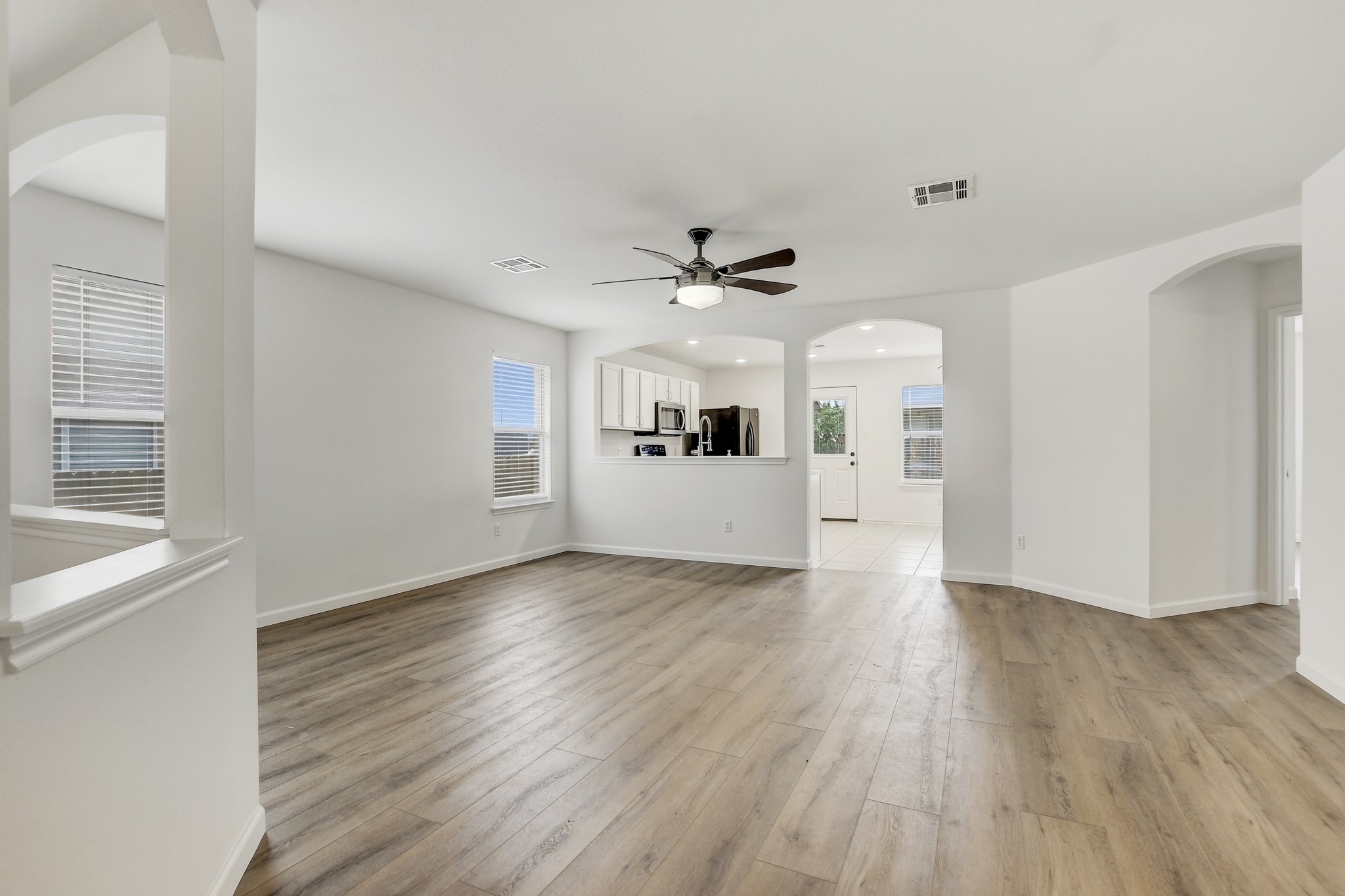 315 Northern Trail Leander, TX 78641 - Photo 7 of 30 a view of a livingroom with wooden floor a ceiling fan and windows