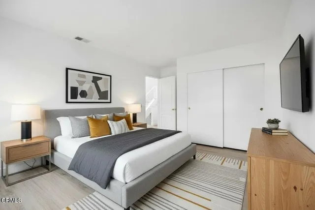 a bedroom with a bed and a flat screen tv