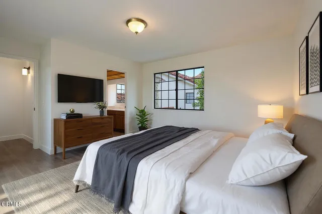 a bedroom with a bed and a flat screen tv