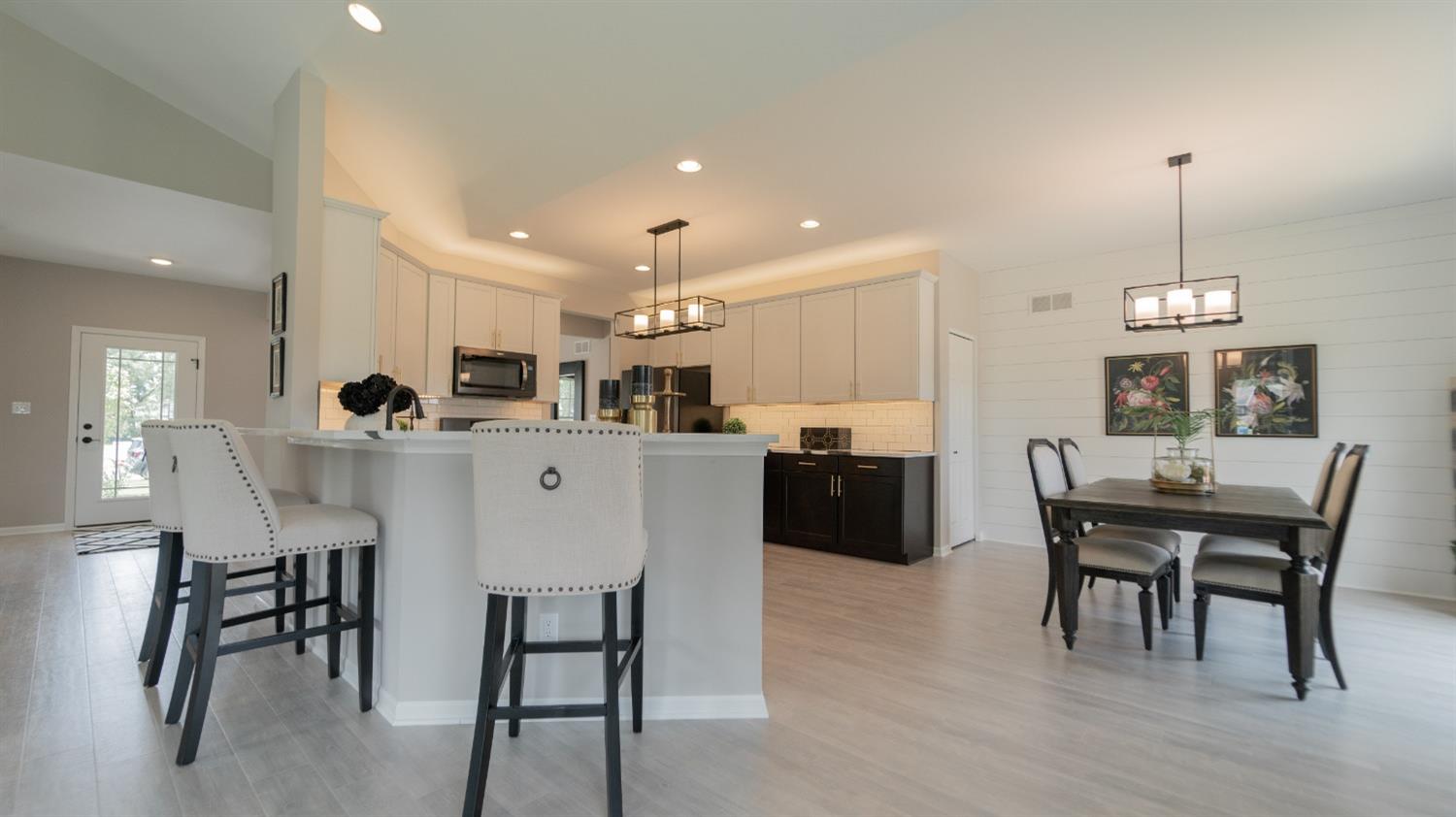 8713 Burr Rdg Circle Crown Point, IN 46307 - Photo 14 of 21 a kitchen with stainless steel appliances kitchen island granite countertop a dining table chairs and white cabinets