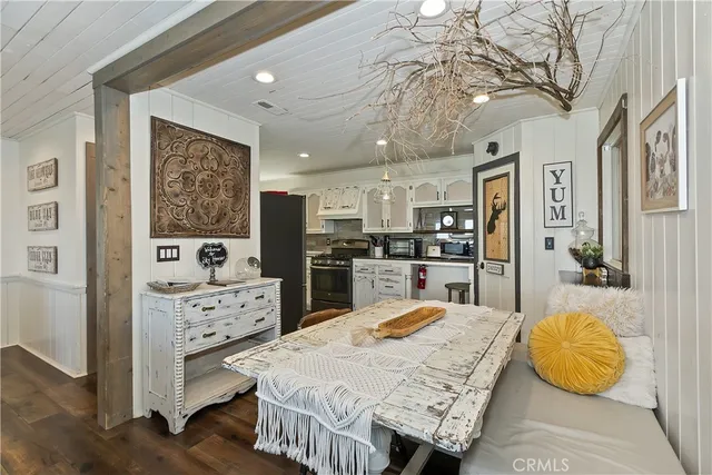 a large kitchen with stainless steel appliances kitchen island granite countertop a refrigerator stove oven a sink dishwasher and white cabinets with wooden floor