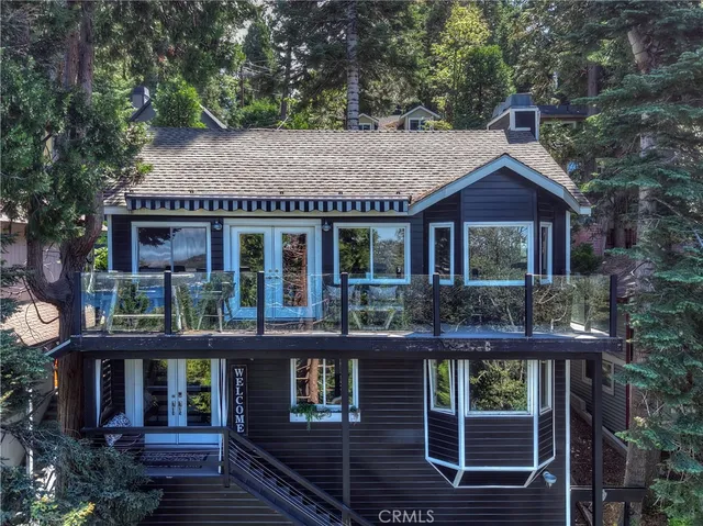 a front view of a house with glass windows and plants