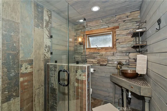 a bathroom with a granite countertop shower a sink and a mirror