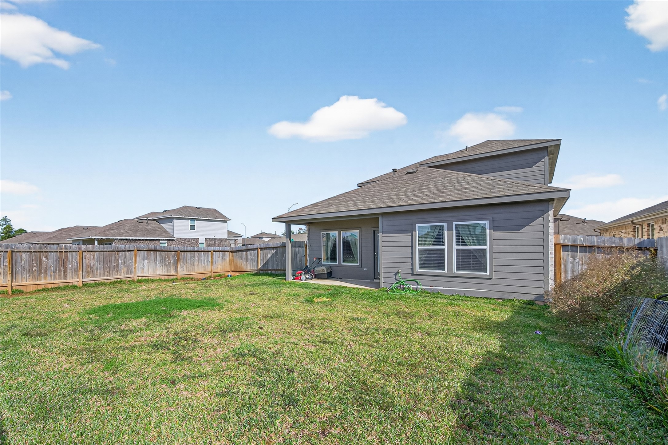24251 Copperleaf Bay Ln Spring Spring, TX 77373 - Photo 40 of 42 a view of a house with a yard and table and chairs under wooden roof
