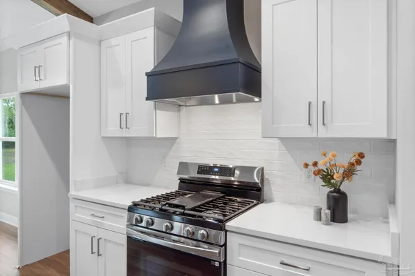 a kitchen with white cabinets and appliances