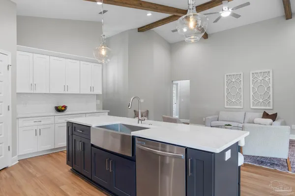 a kitchen with a sink a stove a refrigerator and white cabinets