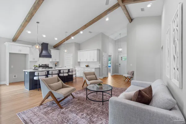 a living room with furniture and a view of kitchen