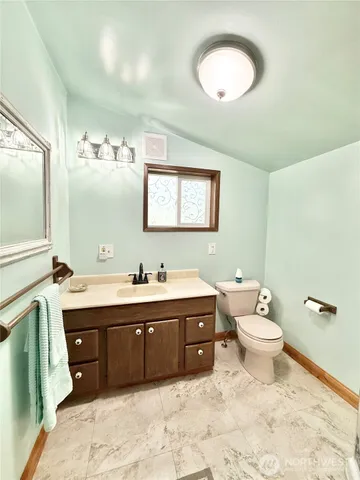 a spacious bathroom with a double vanity sink toilet mirror and bathtub