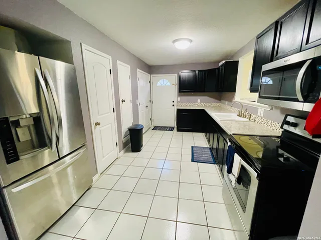 a kitchen with stainless steel appliances a refrigerator and a stove top oven