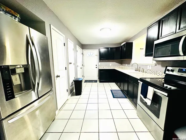 a kitchen with stainless steel appliances a refrigerator sink and microwave