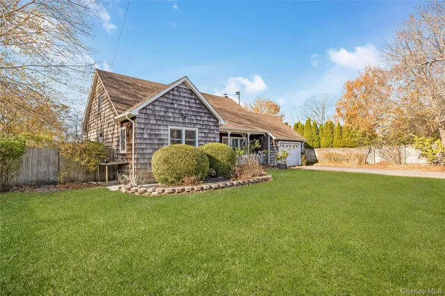 a front view of a house with a garden and yard