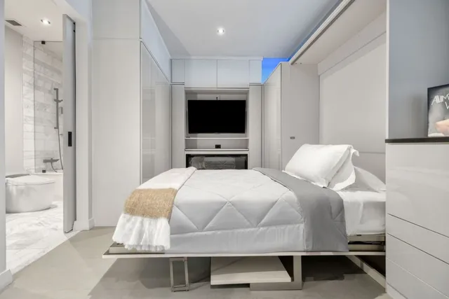 a bedroom with a bed window and a flat screen tv