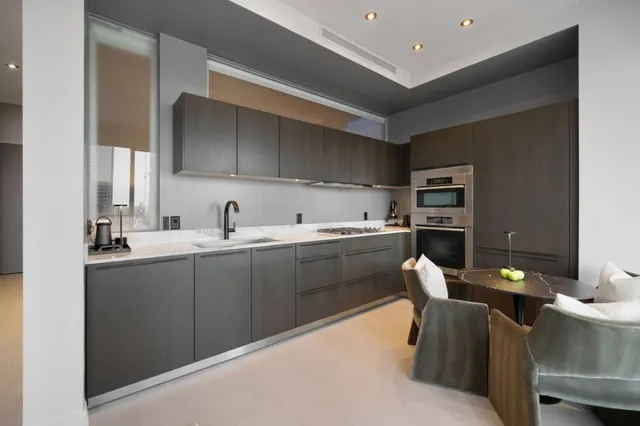 a kitchen with cabinets and chairs