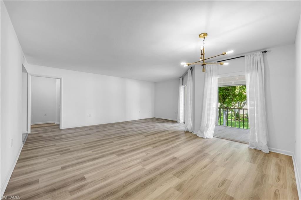 3200 Binnacle Drive, Unit B4 Naples, FL 34103 - Photo 5 of 25 a view of an empty room with wooden floor ceiling fan