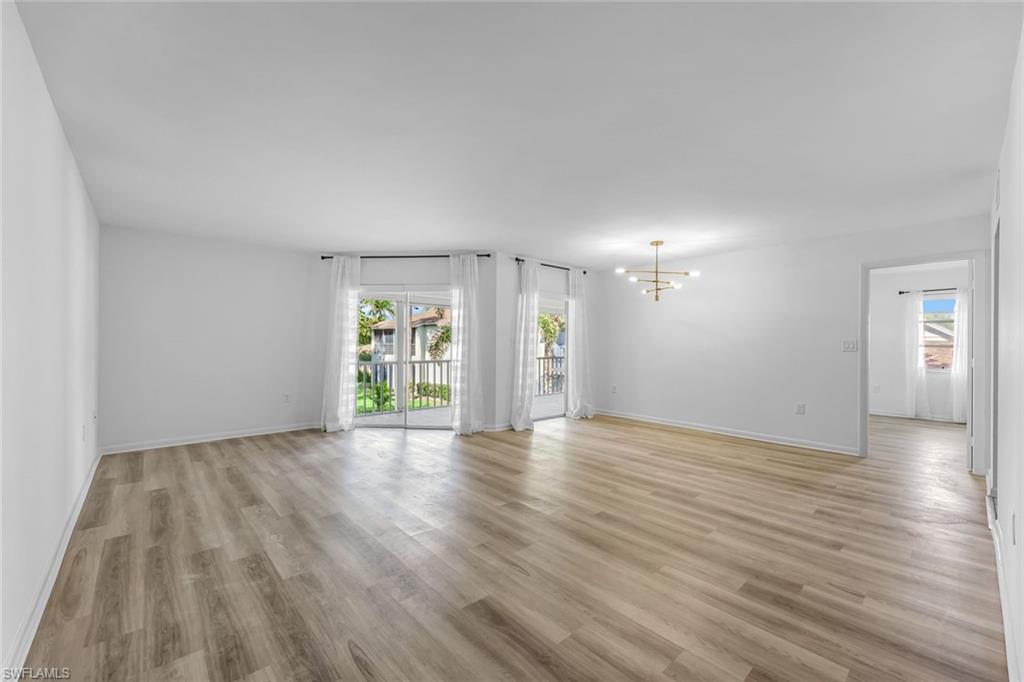 3200 Binnacle Drive, Unit B4 Naples, FL 34103 - Photo 6 of 25 a view of an empty room with wooden floor and windows