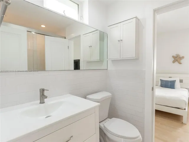 a bathroom with a sink a toilet and a mirror