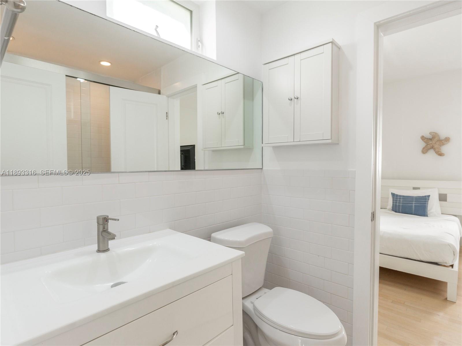 241 28th Street, Unit 1 Miami Beach, FL 33140 - Photo 12 of 16 a bathroom with a sink a toilet and a mirror