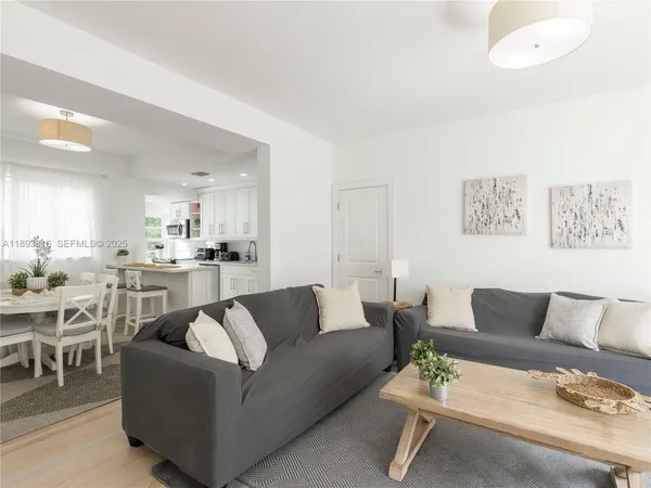 a living room with furniture and view of kitchen