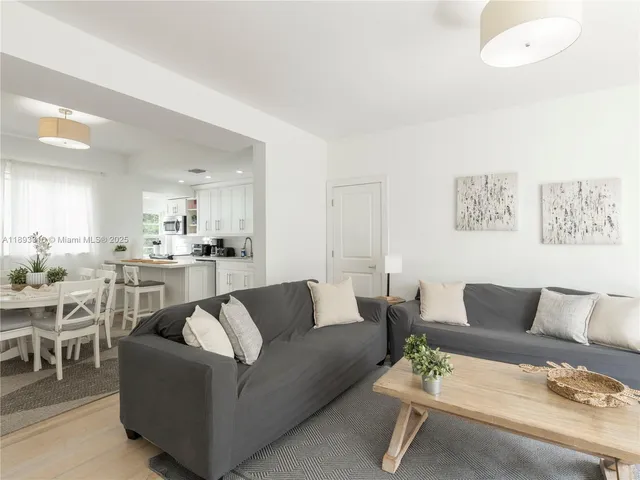 a living room with furniture and view of kitchen