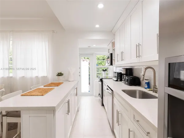 a kitchen that has a sink a stove and window