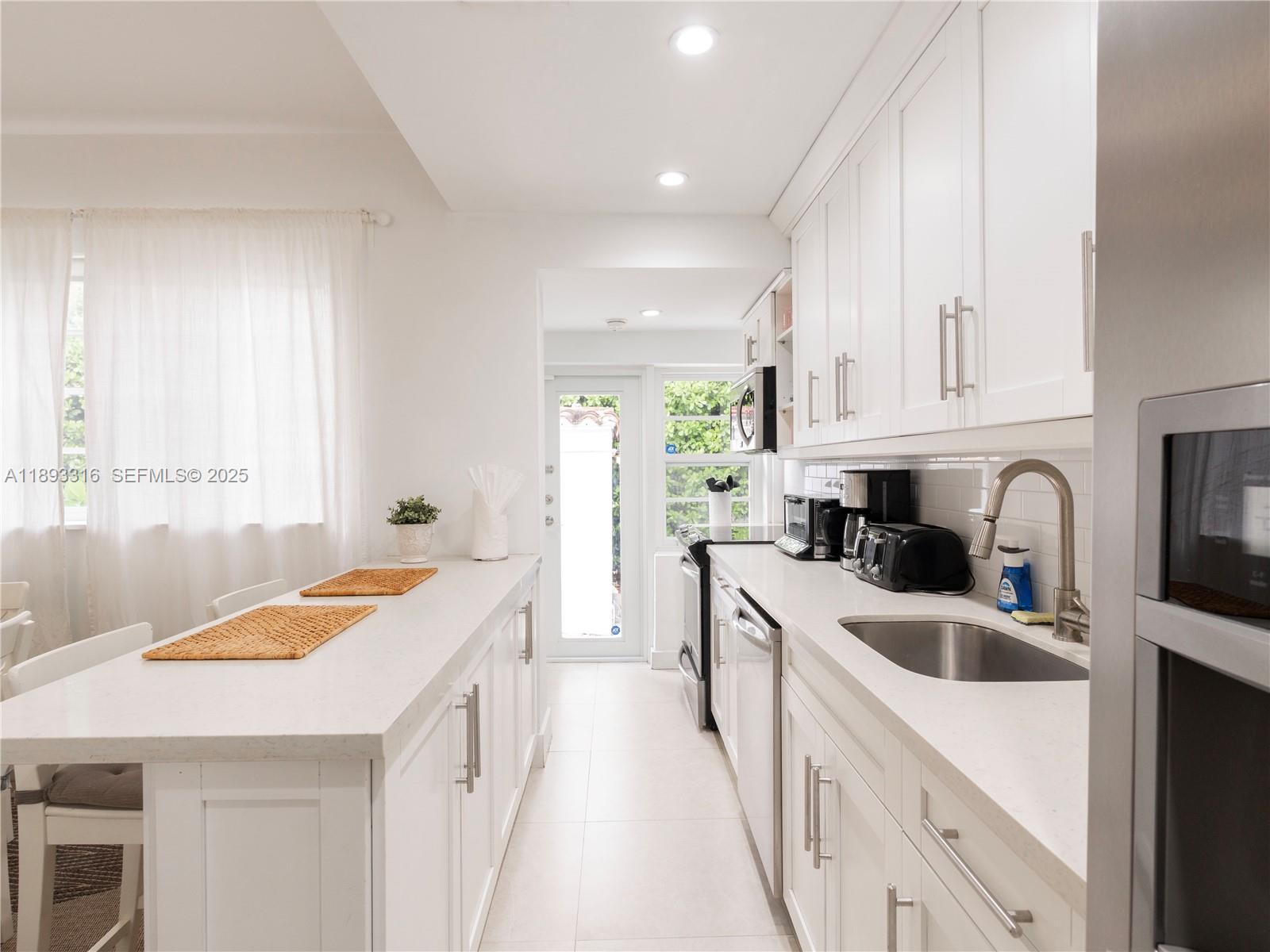 241 28th Street, Unit 1 Miami Beach, FL 33140 - Photo 6 of 16 a kitchen that has a sink a stove and window
