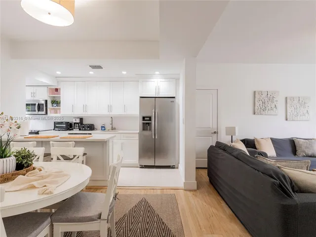 a living room with stainless steel appliances granite countertop furniture and a couch