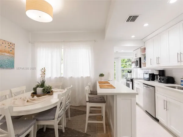 a kitchen with a table chairs sink and cabinets