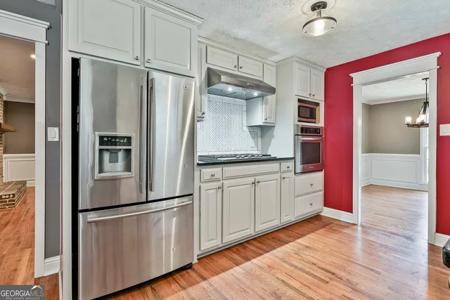 a kitchen with stainless steel appliances granite countertop a refrigerator and a sink