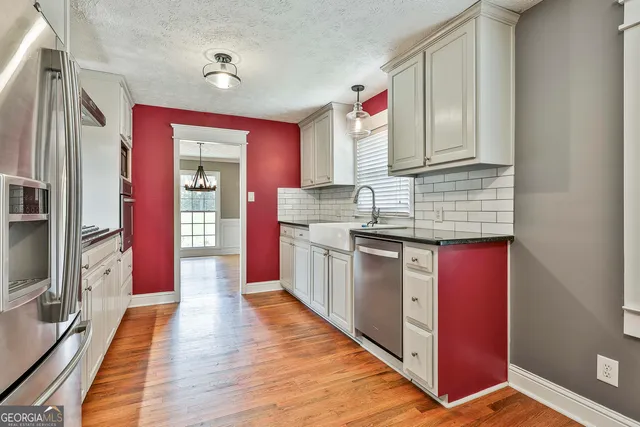 a kitchen with stainless steel appliances granite countertop a stove cabinets and wooden floor